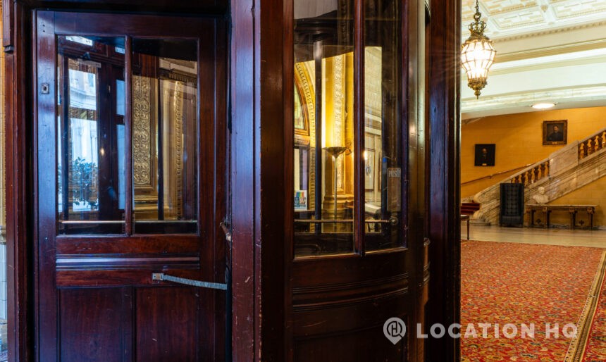 Members club winding staircase brass lift elevator